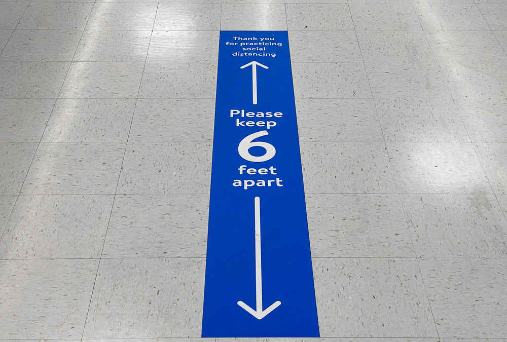 Social distancing floor sign warning about safe distance between people of 6 feet.