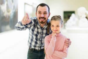 father and daughter viewing museum exhibit