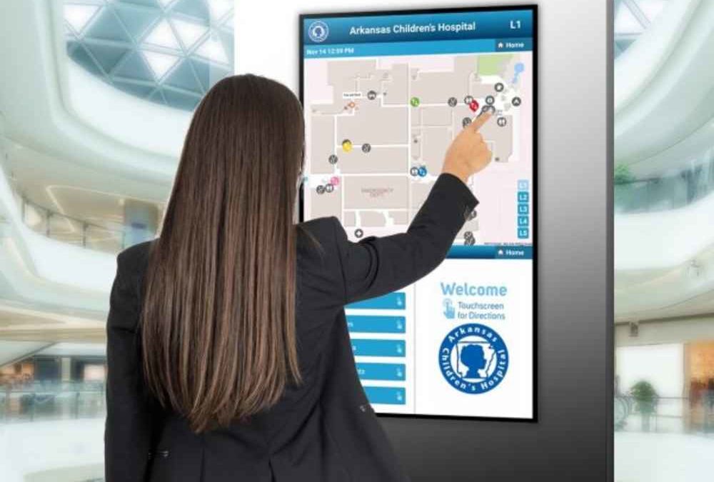 woman interacting with touchscreen sign