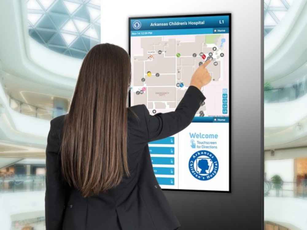 woman interacting with touchscreen sign