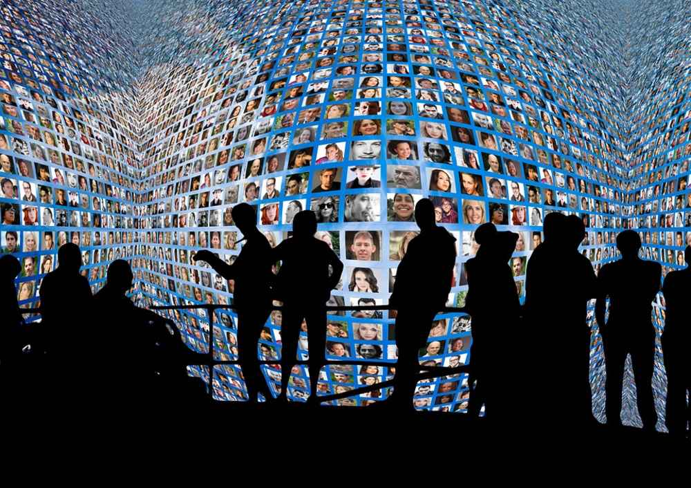 users silhouetted against endless screens social media concept